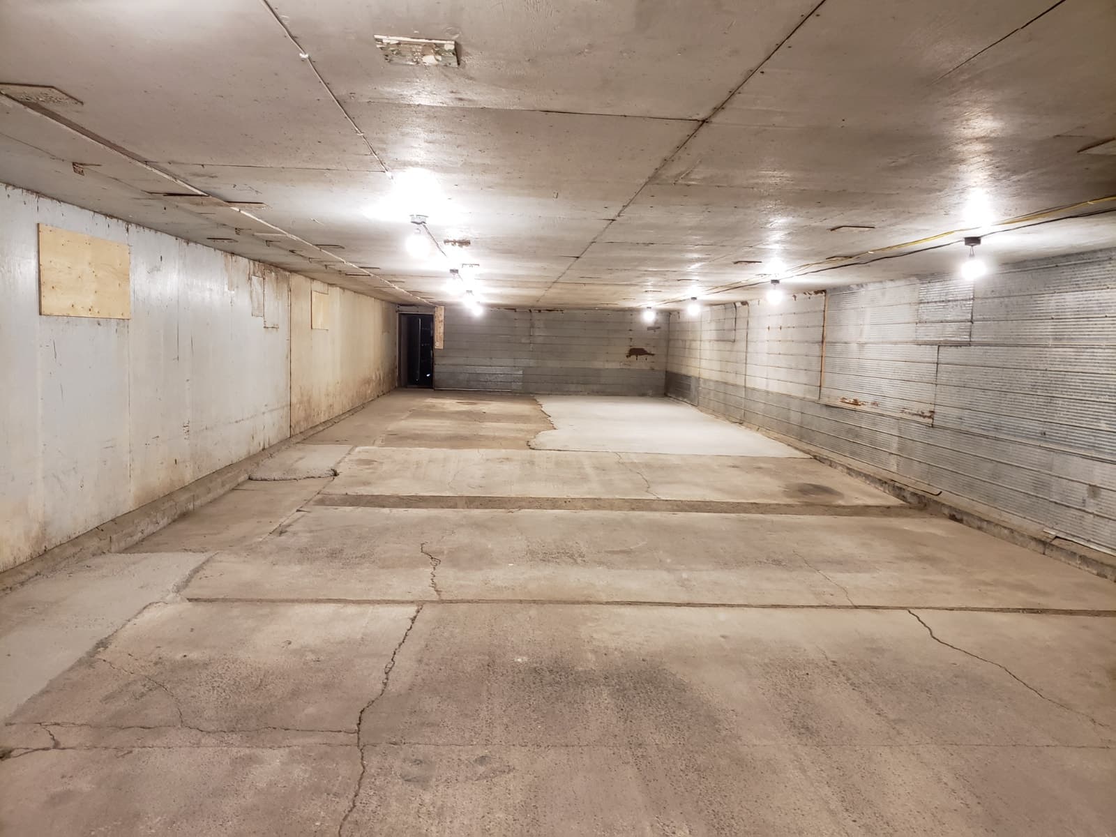 Indoor vehicle storage bay with concrete floor