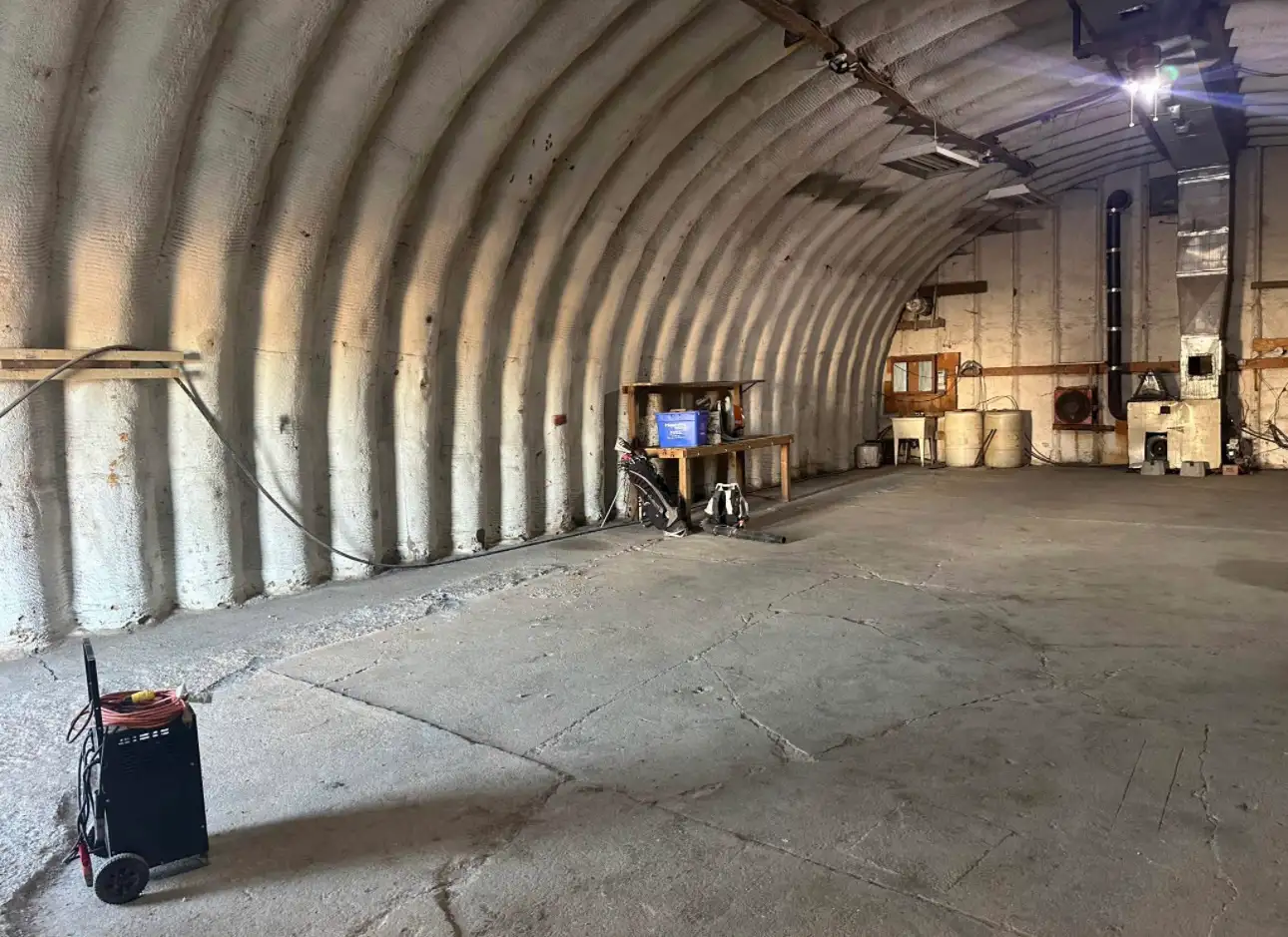 Inside: insulated arched ceiling, concrete floor, furnace on the right